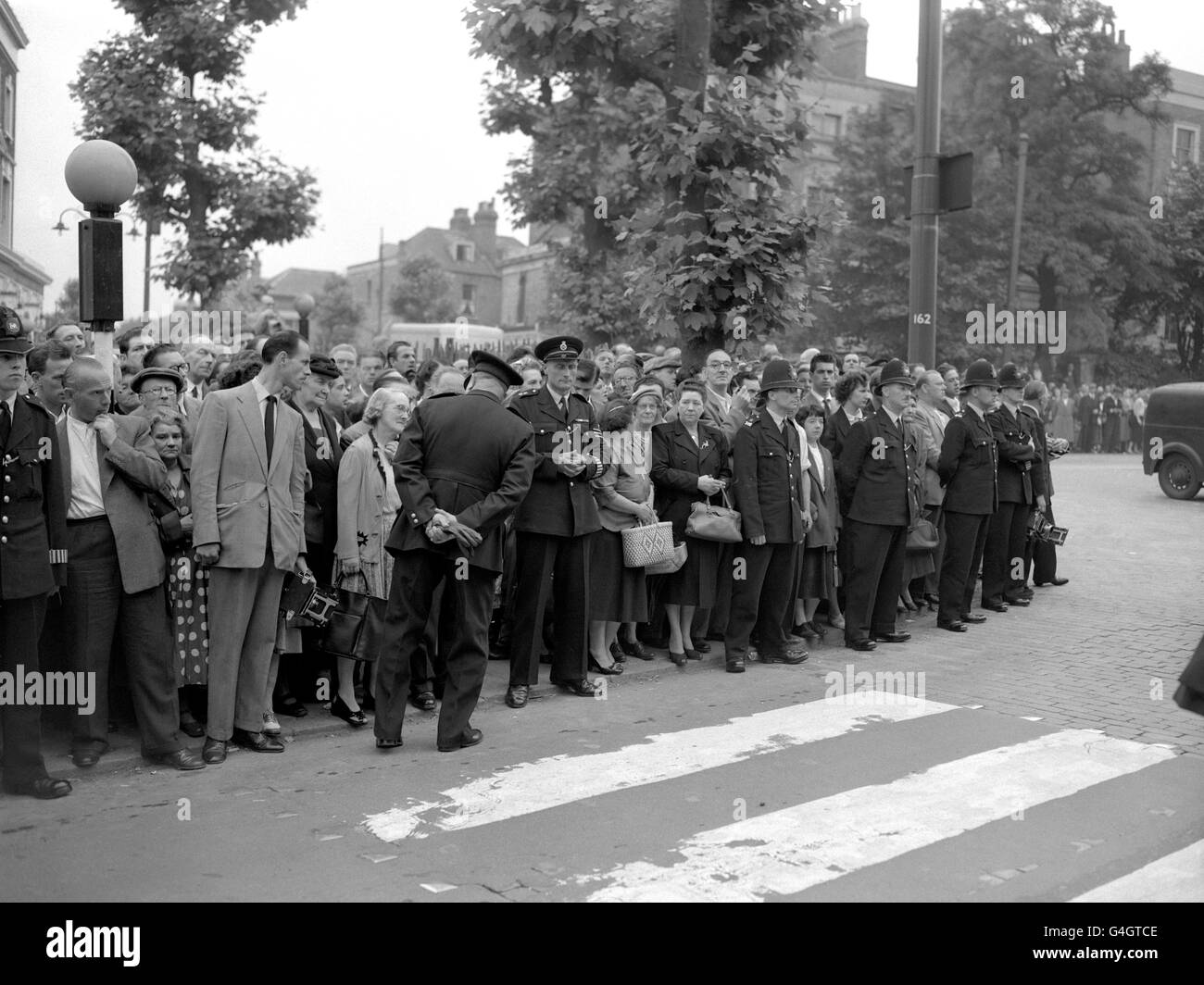 A line of police keeps the crowd from approaching the gates of Holloway Prison in London as Ruth Ellis is executed for the murder of her lover, racing car driver David Blakely. She was the last woman to be hanged in Britain. Stock Photo
