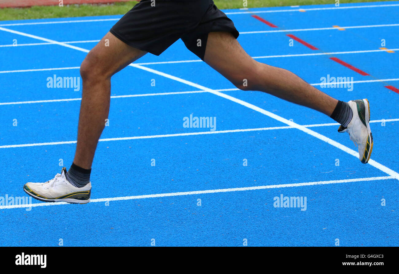 long legs of fast runner runs into the in athletics track Stock Photo