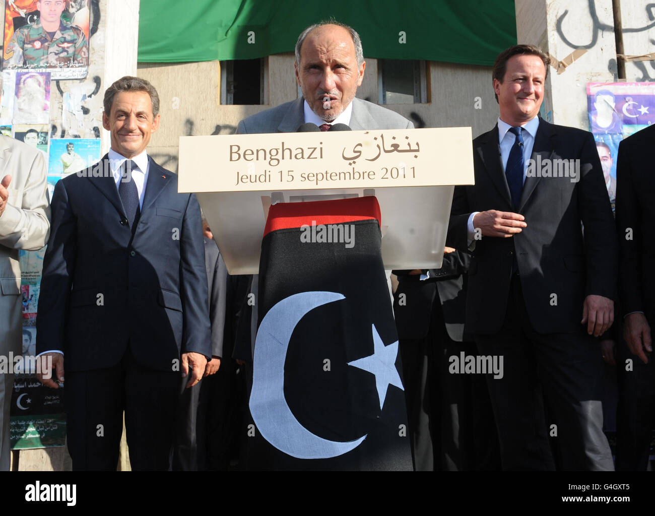 Leader of Libya's interim government, Mustafa Abdul-Jalil makes a speech flanked by French President Nicholas Sarkozy and Prime Minister David Cameron during their visit to Benghazi. Stock Photo