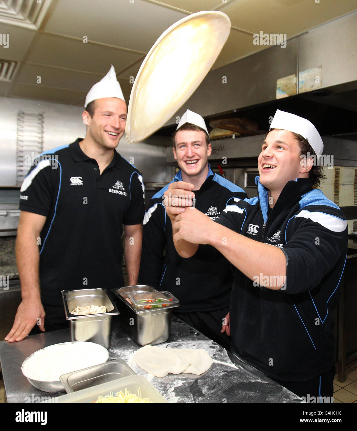Glasgow Warriors (left to right) James Eddie and Stuart Hogg watch Finlay Gillies during a photocall at Paperinos, Glasgow Stock Photo