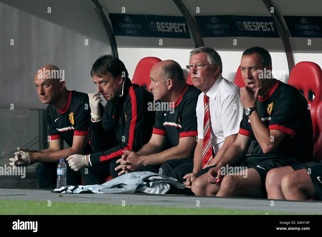 Manchester United's Head Physiotherapist Rob Swire (left), Assistant Manager Mick Phelan (centre), Manager Sir Alex Ferguson (2nd right) and First Team Coach Rene Meulensteen (right) on the bench Stock Photo