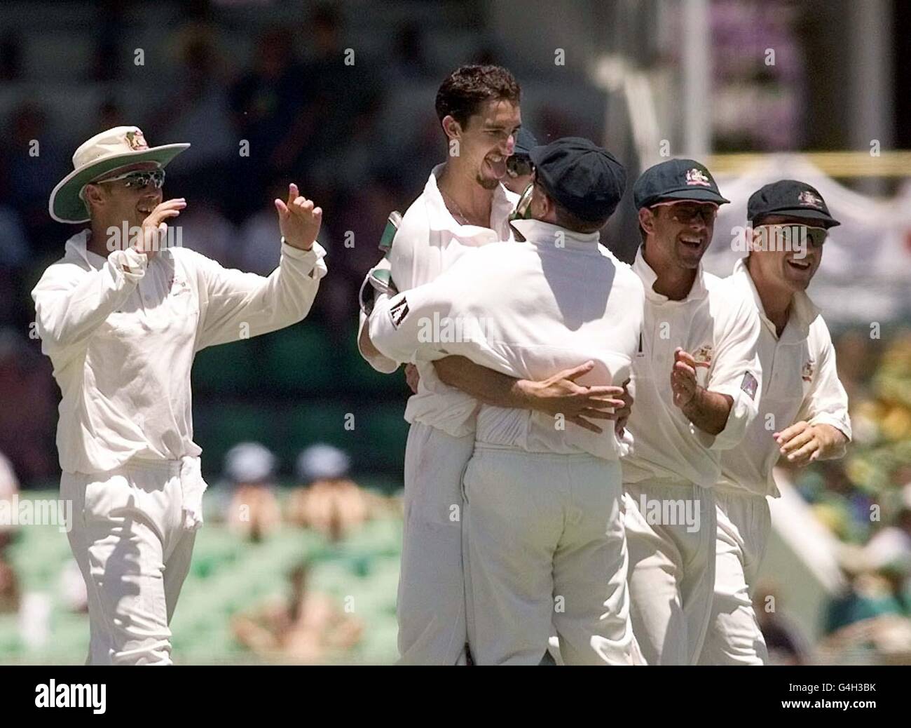 Captain Mark Taylor embraces Australian bowler Jason Gillespie (centre) after taking a series of wickets and causing England to accept defeat in the Second Test at Perth today (Monday). Picture by BEN CURTIS/PA. **EDI** Stock Photo