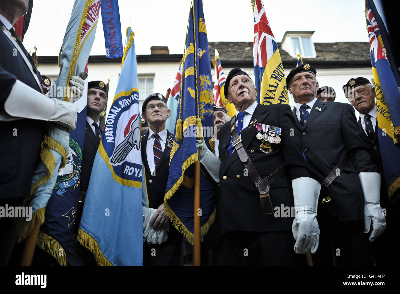 Royal British Legion standard bearers gather to listen to a briefing on the High Street of Wootton Bassett as they prepare to hand over the ceremonial flag to Oxford where the bodies of fallen servicemen will now be repatriated into the UK at RAF Brize Norton. Stock Photo