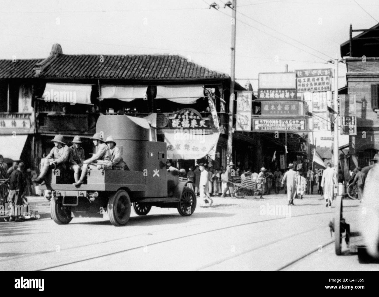 A British armoured car patrol passing through one of the streets in Shanghai, during the 'China Crisis'. Stock Photo
