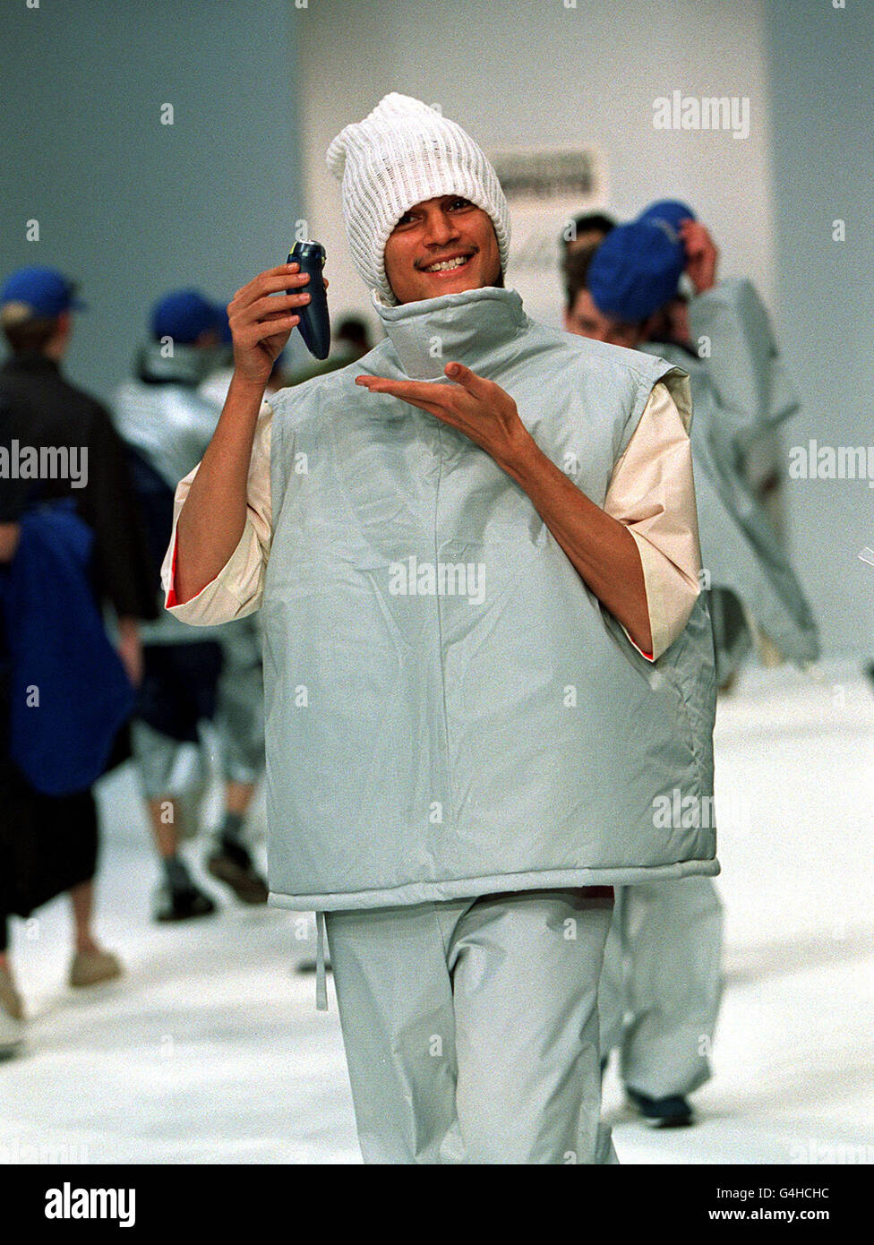 A grinning model holding a phillishave electric shaver presents a light jacket and matching trousers from budding designers at Northbrook College is modelled on the catwalk at the Royal Horticultural Halls in London as part of Men's Fashion Week. Stock Photo