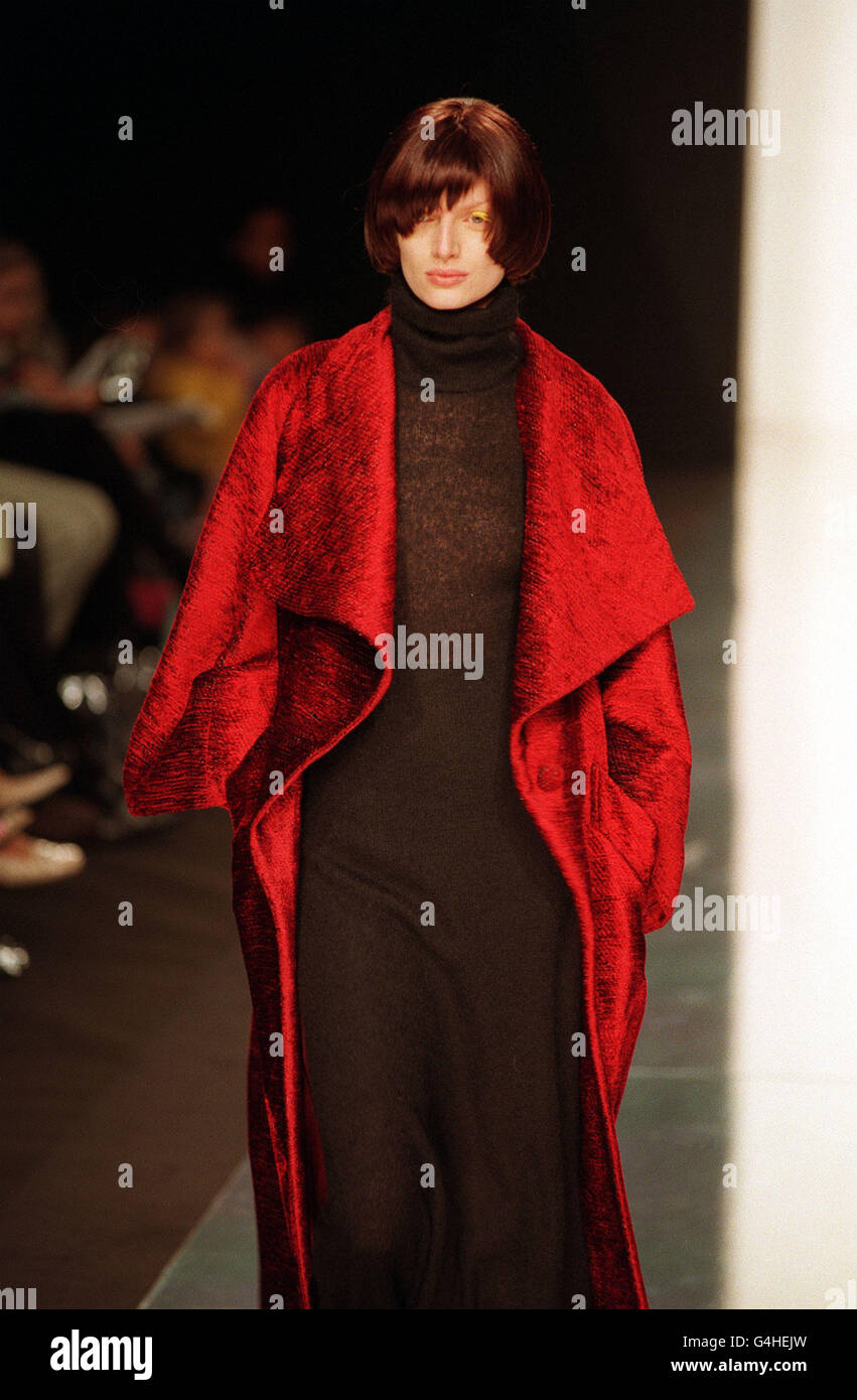 A model wears a black knitwear dress and red overcoat during Maria Grachvogel's show at The Natural History Museum as part of London Fashion Week. Stock Photo