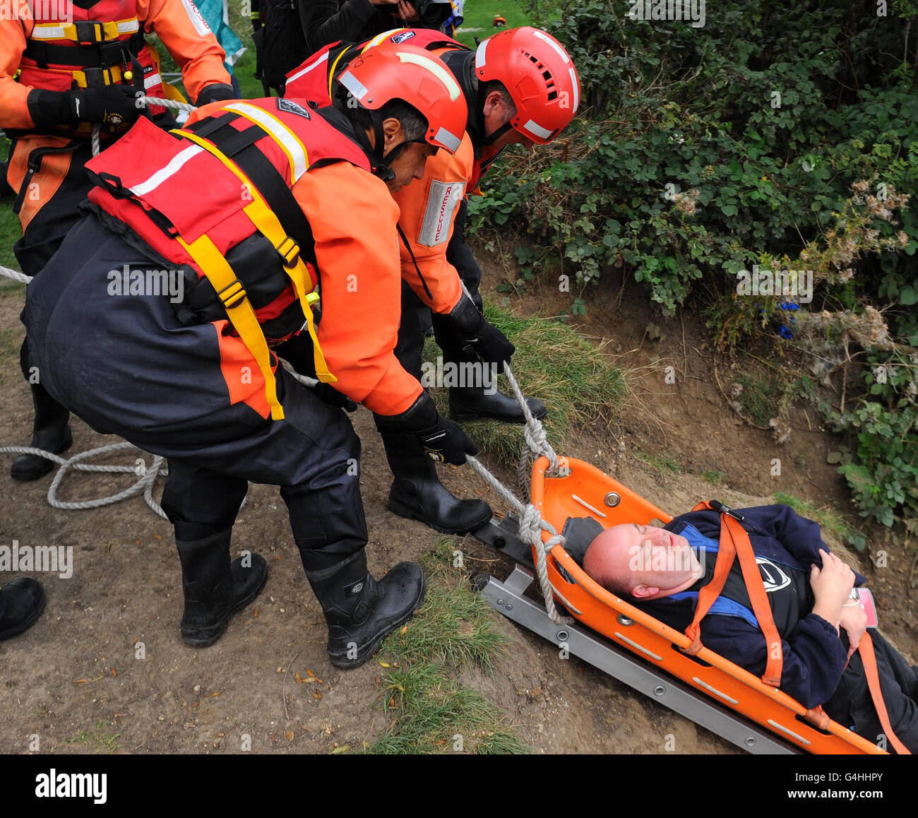 Firefighters move a casualty on a stretcher during a river rescue training exercise, at Hackney Marshes, in north east London. Stock Photo