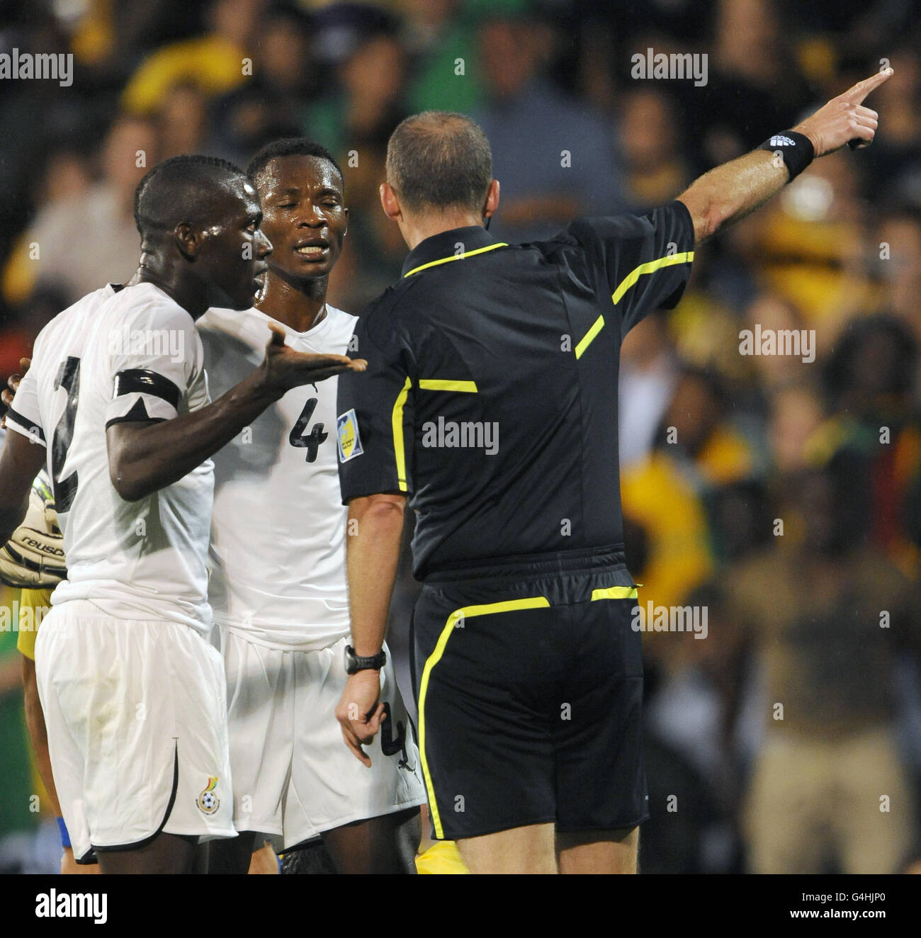 Soccer - International Friendly - Brazil v Ghana - Craven Cottage. Ghana's Daniel Opare (left) protests to referee Mike Dean after being shown a red card against Brazil. Stock Photo