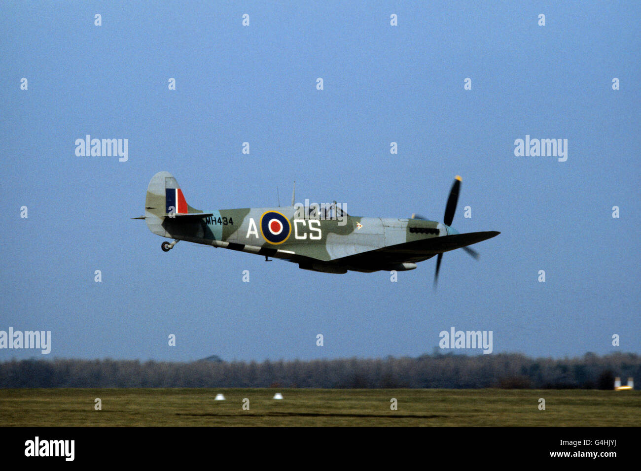 A World War Two Spitfire Mk IX in flight before it goes up for auction by Christie's at the Imperial War Museum, Duxford Stock Photo