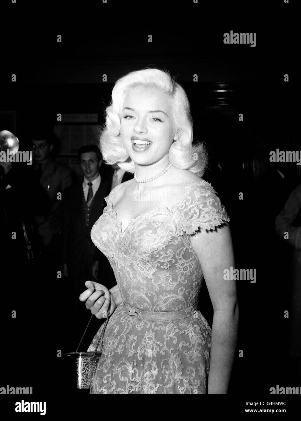 Actress Diana Dors is in a laughing mood as she arrives at the Odeon Leicester Square, London, for the premiere of the film 'As Long As They're Happy' and the presentation of the British Film Academy Awards. Stock Photo