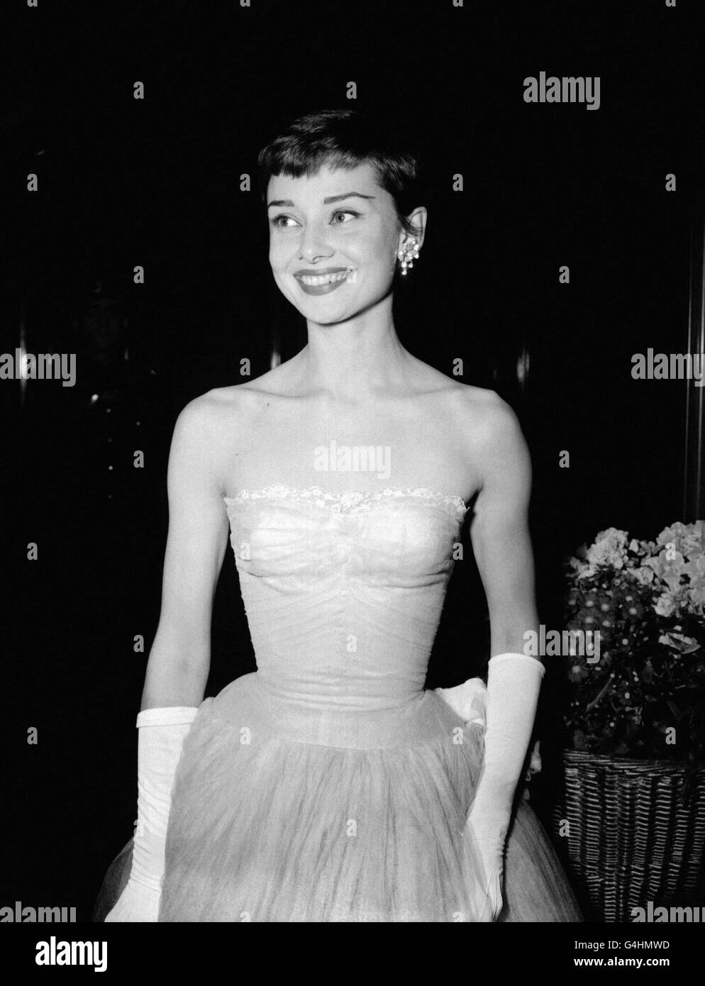 Actress Audrey Hepburn smiles broadly as she arrives at the Odeon Leicester Square, London, for the premiere of the film 'As Long As They're Happy' and the presentation of the British Film Academy Awards. Stock Photo