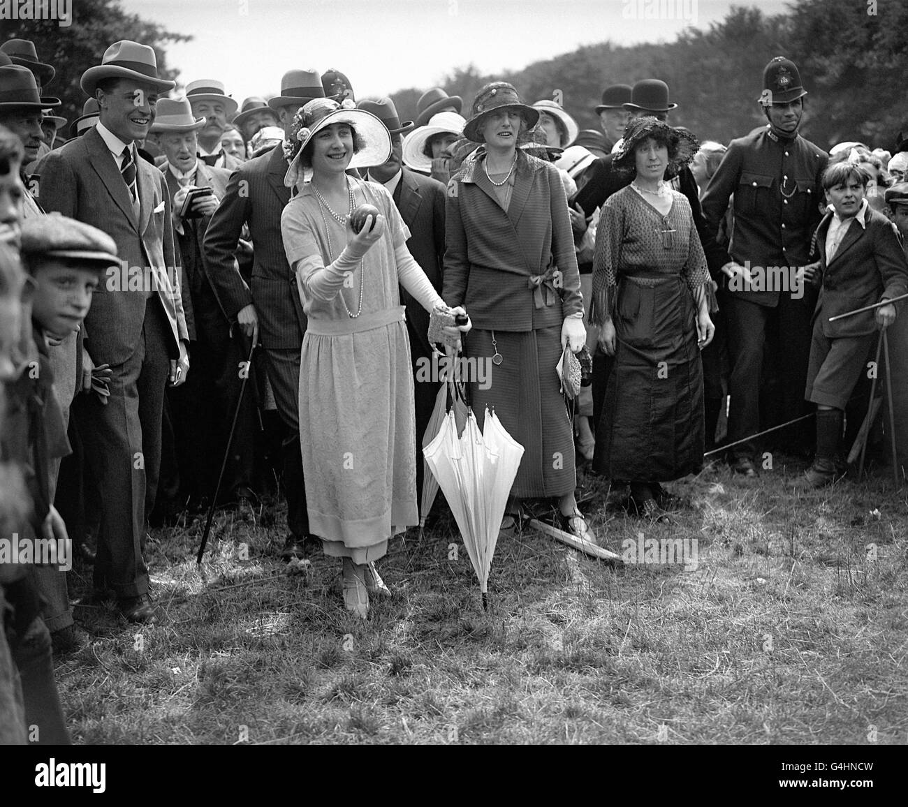 The Duke and Duchess of York (later Queen Elizabeth and King George VI) and the Fresh Air Fund children in Epping Forest. The duchess tries her hand at the coconut shy. Stock Photo