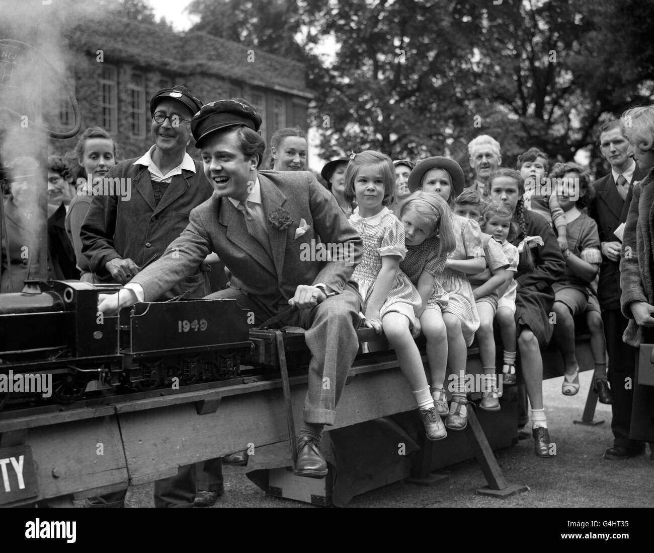 FILM ACTOR RICHARD ATTENBOROUGH PILOTED A TRAINLOAD OF CHILDREN AROUND THE GROUNDS OF THE MODEL RAILWAY DURING THE CARNIVAL AT THE BEDFORD COLLEGE, REGENTS PARK IN LONDON Stock Photo