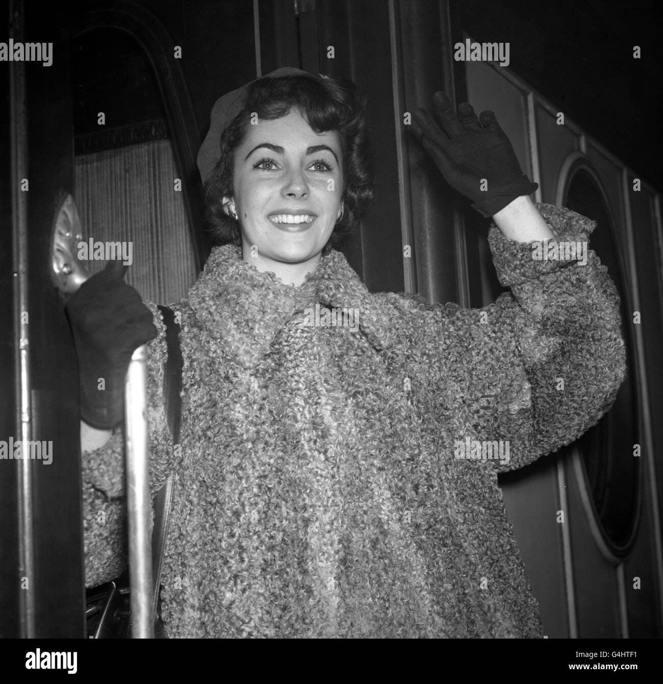 Sixteen-year-old British actress Elizabeth Taylor leaving Victoria Station in London for Paris, where she will spend a few days before going to the United States to see her fiance American football star Glen Davis. Stock Photo
