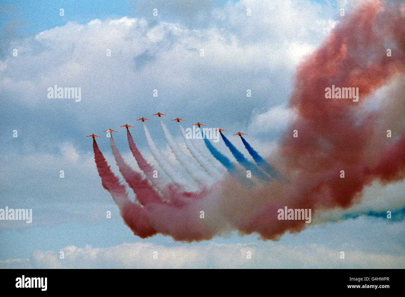 Red, white and blue smoke trails by the Red Arrows aerobatics team in a close to the flying display, at the Royal Review of the Royal Air Force, at RAF Finningley, during Queen Elizabeth II's Silver Jubilee tour of Great Britain Stock Photo