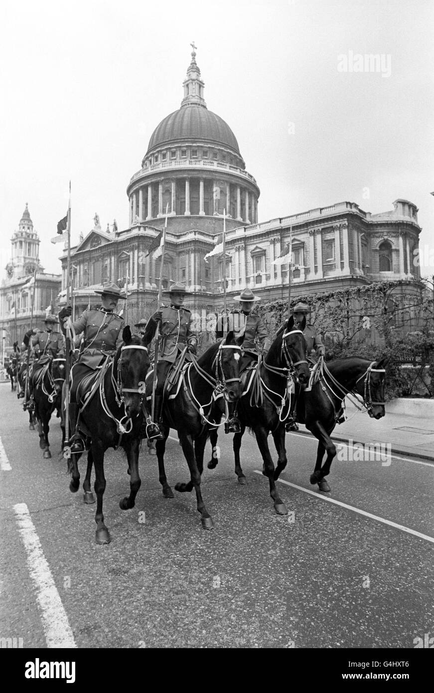 Members of a 36 man troop of the Royal Canadian Mounted Police, in London on a seven week tour to mark the Silver Jubilee, ride past St Paul's Cathedral as they accompany the Canadian High Commissioner, Paul Martin, from Canada House to Mansion House. Stock Photo