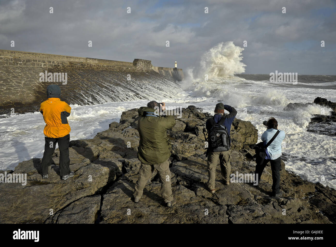 Photographers gather to take photographs of the waves striking the harbour wall at Porthcawl, Wales as the remnants of Hurricane Katia hit British shores. Stock Photo