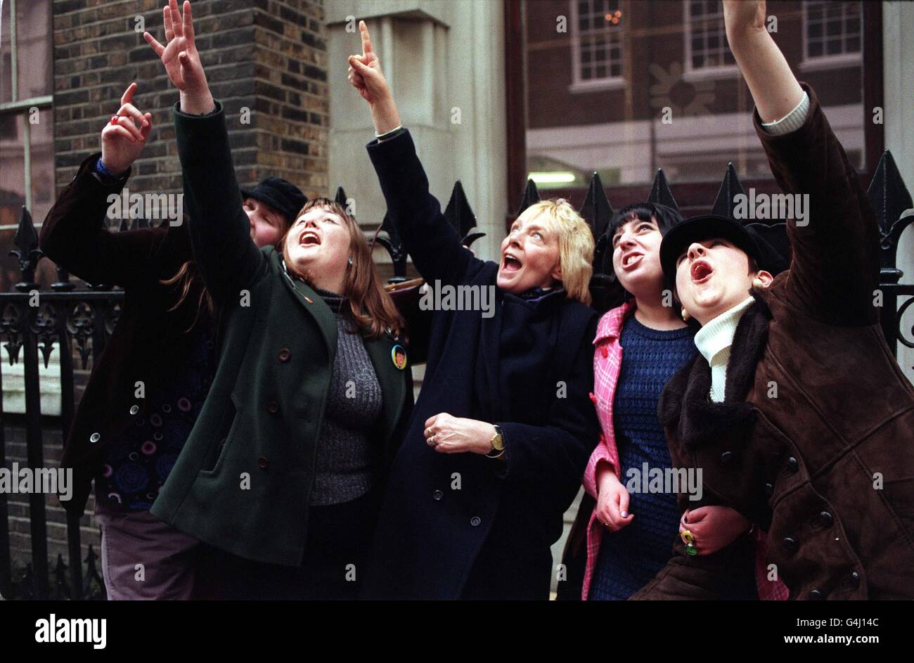 Screaming Beatles fans look up to the roof of the former Apple HQ in Savile Row, London, where the Bootleg Beatles tribute group where re-enacting the original set played by the Beatles in the 1970s. Stock Photo