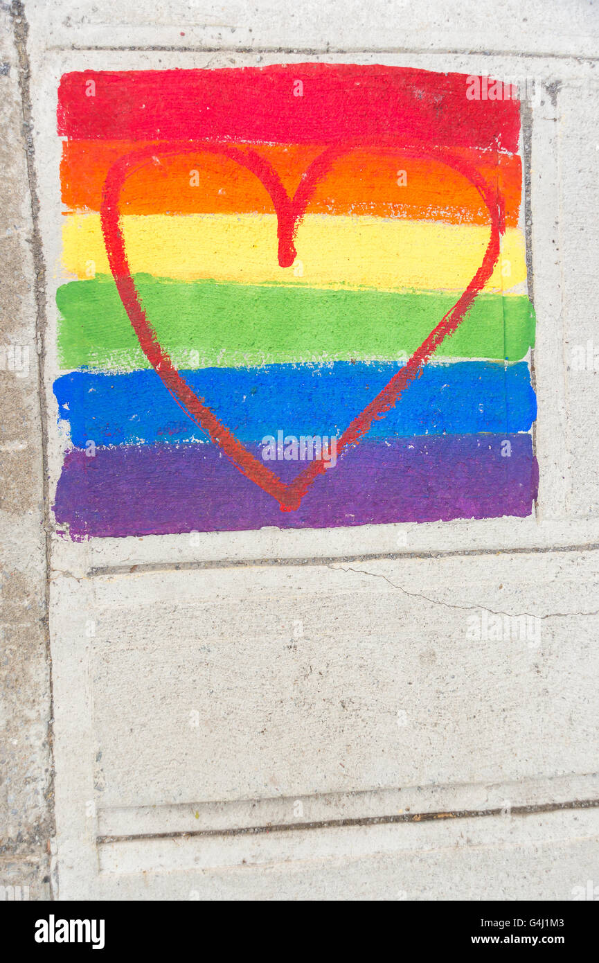 Gay rainbow flag and red heart painted on a sidewalk Stock Photo