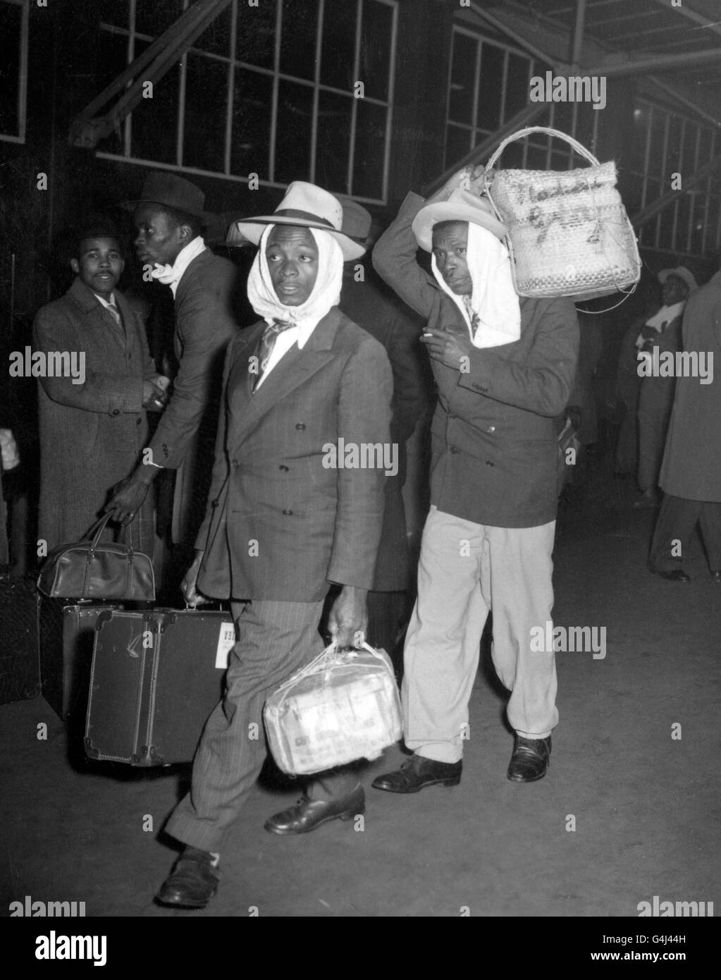 With heads muffled against the cold, men from Jamaica arrive at Victoria Station, London, in search of jobs and somewhere to live. They were among 400 Jamaicans, who had landed at Folkestone after travelling across Europe. Stock Photo