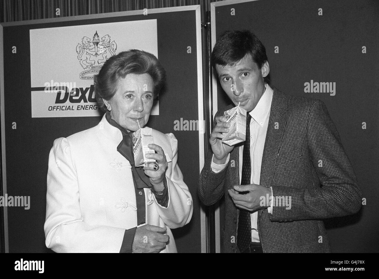 Ice Skating coach Betty Callaway (l), coach to Jayne Torvill and Christopher Dean (not pictured), with athlete Seb Coe (r) enjoy a glucose drink in London where the British Association of National Coaches and their sponsor Dextrosol glucose tablets announced the launch of the BANC Dextrosol Coach of the Year Award 1985-86. Stock Photo
