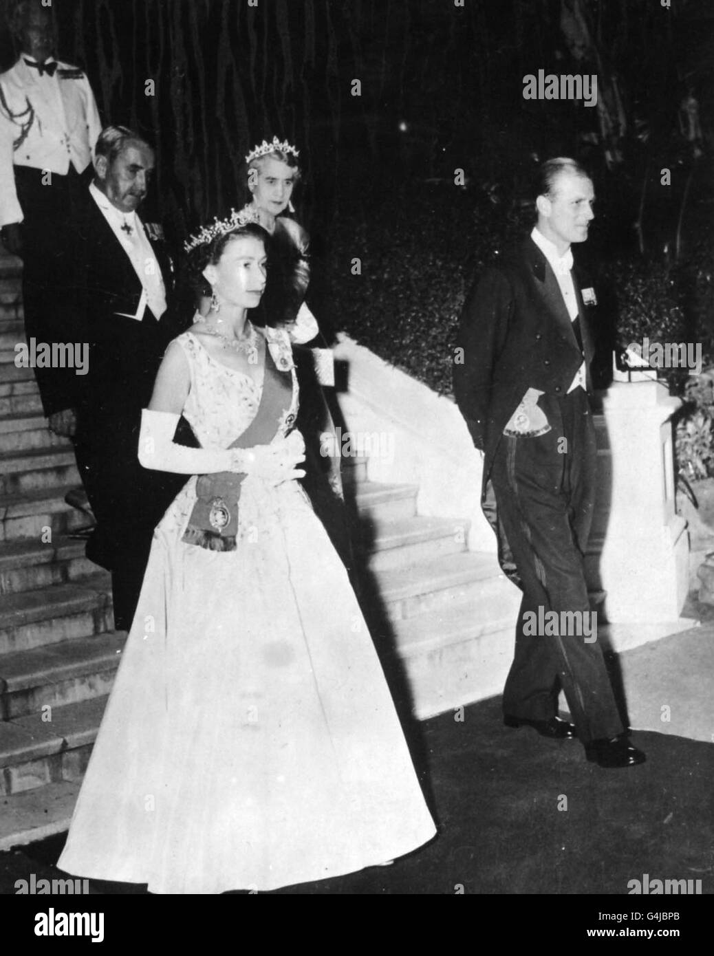 The Queen, escorted by the Duke of Edinburgh, leaves a reception at Government House, Brisbane, Australia. Following her are the Governor of Queensland, Sir John Laverack and Lady Laverack. Stock Photo