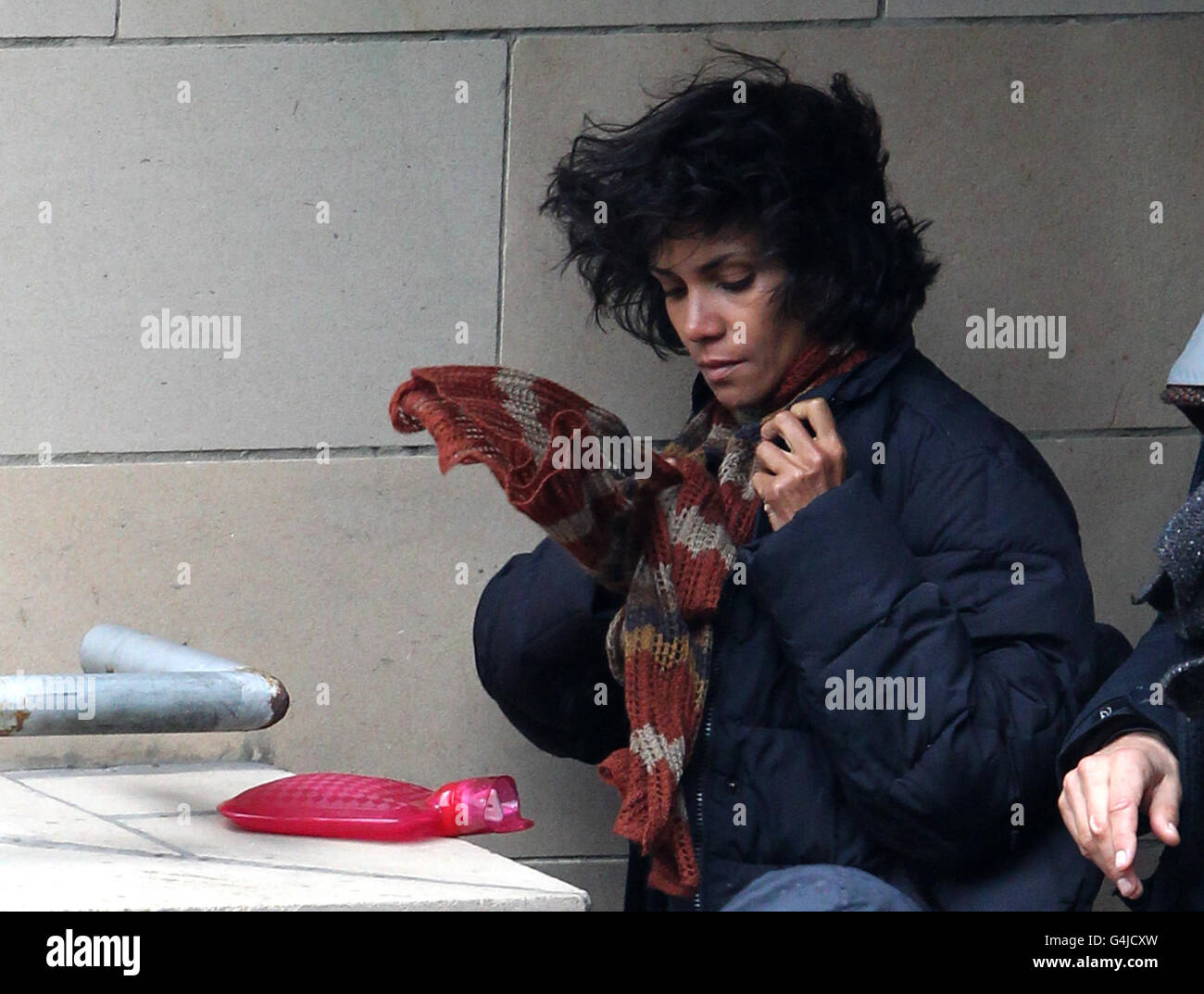 Halle Berry trys to keep warm between takes on the set of her new film Cloud Atlas which is currently being filmed in Glasgow. The film also stars Tom Hanks. Stock Photo