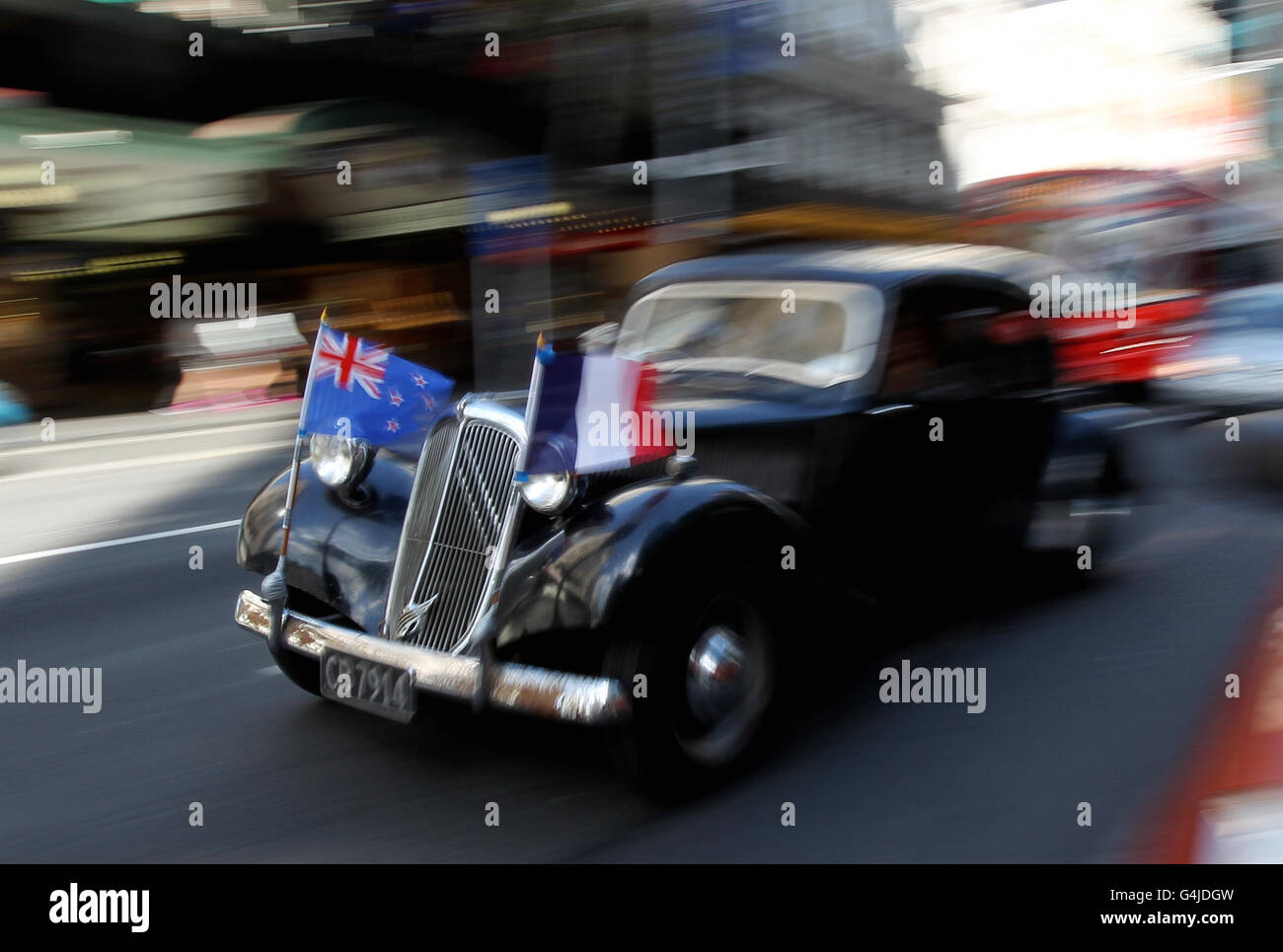 A vintage Citroen shows the flags of New Zealand and France on Queen Street in central Auckland, New Zealand. Stock Photo
