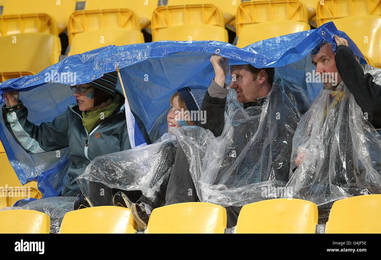 Rugby fans shelter from the rain in the stands hi-res stock photography ...