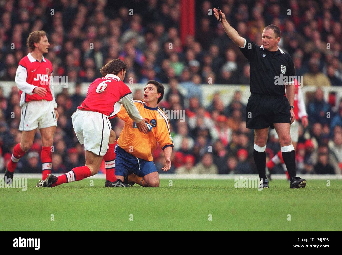 This picture may only be used within the context of an editorial feature. Arsenal's Tony Adams (2nd left) reacts angrily to Derby County midfielder Stefano Eranio's late challenge on him during their FA Cup quarter-final football match at Highbury. Stock Photo