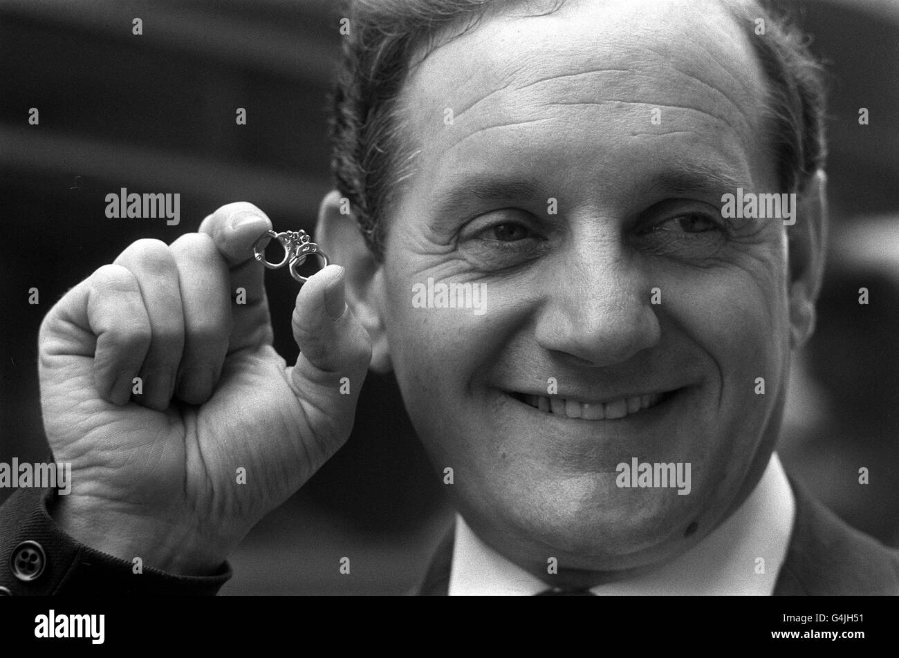 PA NEWS PHOTO 10/3/72 A LIBRARY FILE PICTURE OF LEONARD READ, ASSISTANT CHIEF CONSTABLE OF NOTTINGHAMSHIRE AT THE HOME OFFICE IN WHITEHALL, LONDON HOLDING THE MINIATURE HANDCUFFS TIECLIP Stock Photo