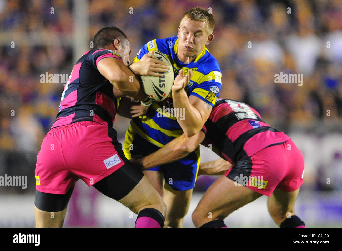 Warrington Wolves' Mike Cooper is tackled by Leeds Rhinos' Ian Kirke and Danny Buderus during the engage Super League, Semi Final match at the Halliwell Jones Stadium, Warrington. Stock Photo