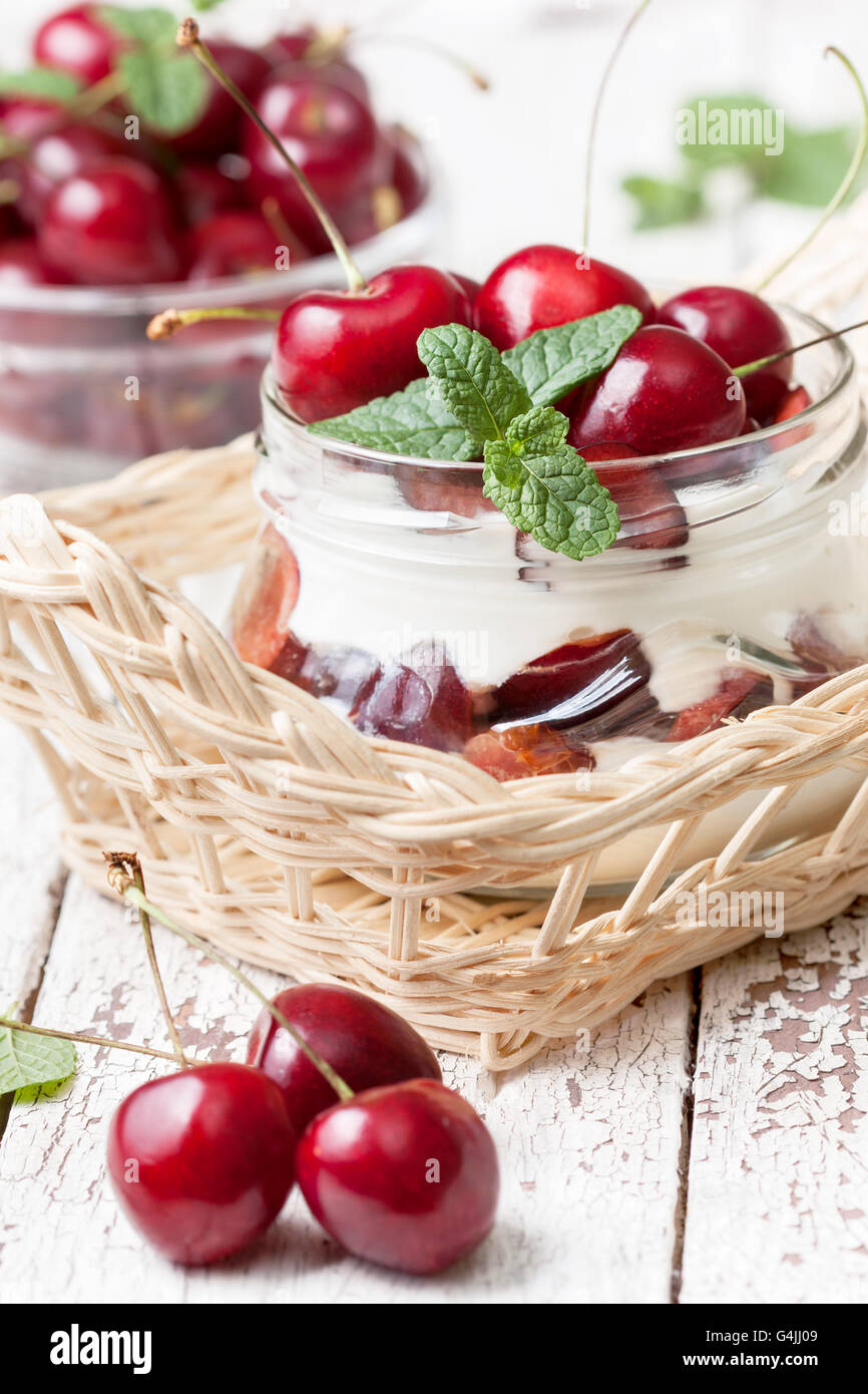 Yogurt with fresh sweet cherries in a glass jar. Dietary breakfast. Stock Photo