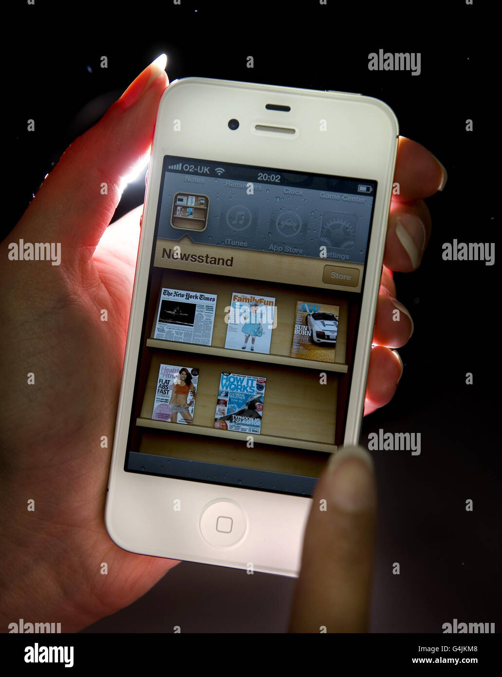 An Apple employee demonstrates the Newsstand app on the latest Apple ...