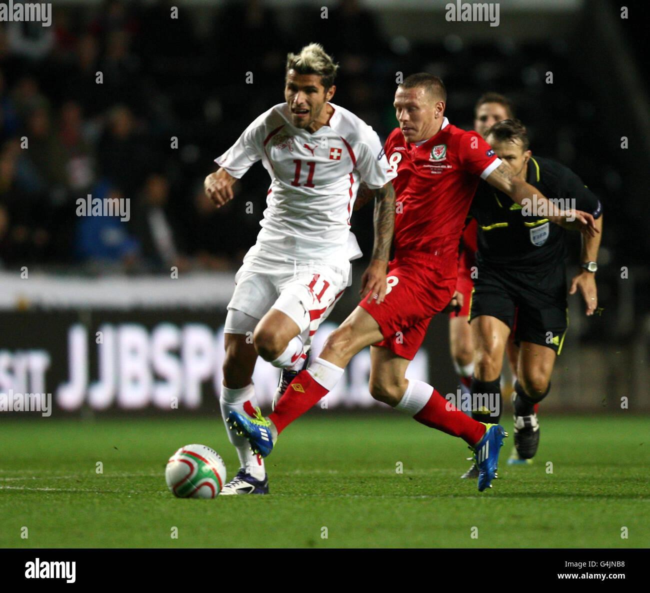 Switzerland's Valon Behrami is challenged by Wales' Craig Bellamy during the Euro 2012 Group G Qualifying match at the Liberty Stadium, Swansea. Stock Photo