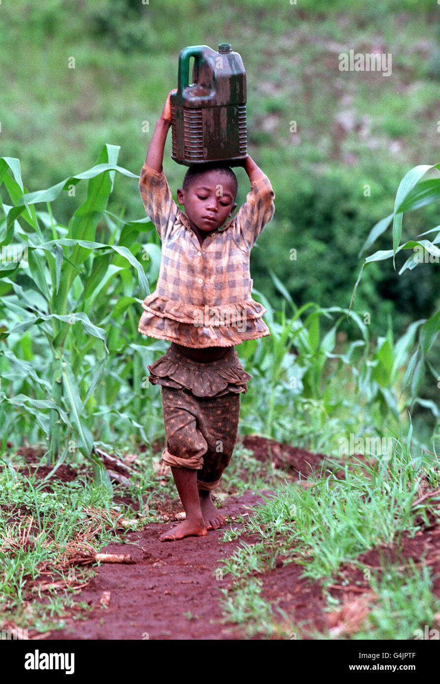 A child carries an oil container filled with water on his head through the fields of Mauala Village, Ludewa District, Tanzania. * This picture was taken during Melanie Clark Pullen's (Mary in Eastenders) trip to East Africa, to highlight the Jubilee 2000 Campaign to cancel Third World debt. Stock Photo