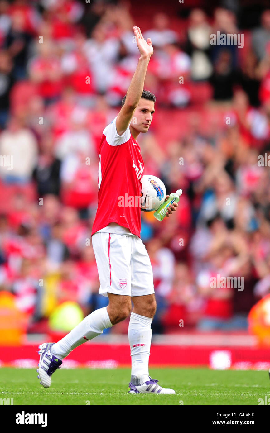 Arsenal's Robin Van Persie leaves the field with the matchball after scoring his 100th Premiership goal Stock Photo