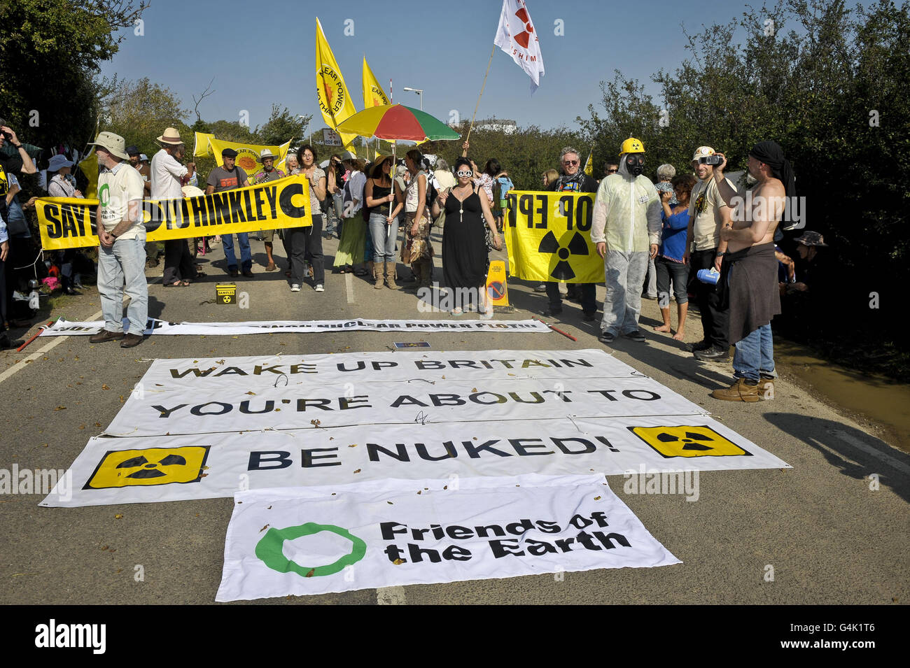 Protestor hold banners outside Hinkley Point power station in Somerset as several anti-nuclear groups who are part of the Stop New Nuclear alliance protest against EDF Energy's plans to renew the site with two new reactors. Stock Photo
