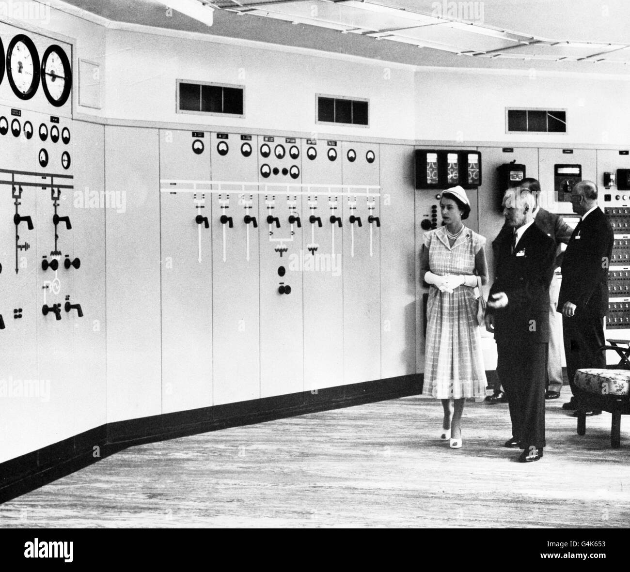 The Queen shows interest during her tour of New Zealand's hydro-electric scheme at Karapiro Power Station. Stock Photo