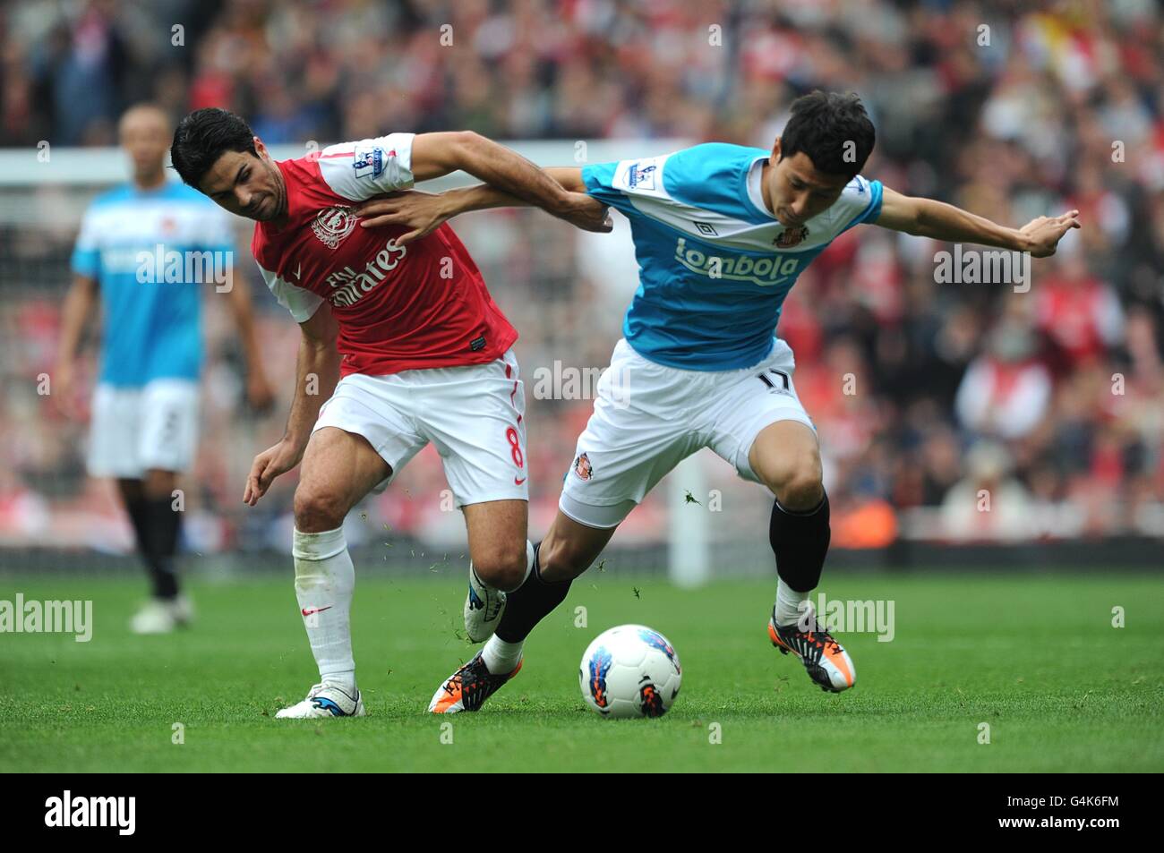 Soccer - Barclays Premier League - Arsenal v Sunderland - Emirates Stadium. Arsenal's Mikel Arteta (left) and Sunderland's Dong-Won Ji battle for the ball Stock Photo