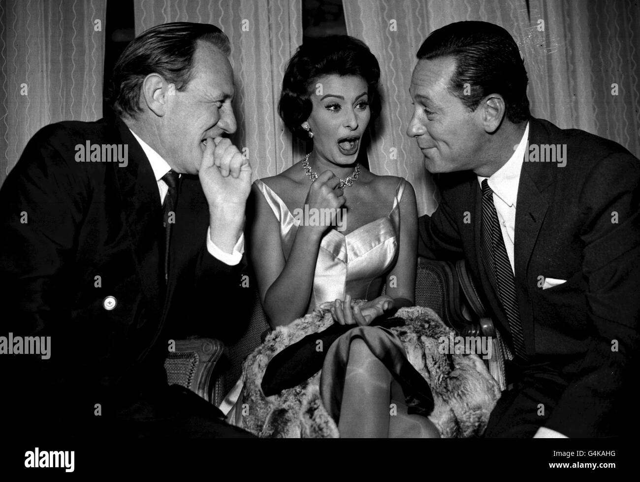 PA NEWS PHOTO 20/10/57 A LIBRARY FILE PICTURE OF SOPHIA LOREN ENJOYING A JOKE WITH WILLIAM HOLDEN (LEFT) AND TREVOR HOWARD AT THE SAVOY HOTEL IN LONDON Stock Photo