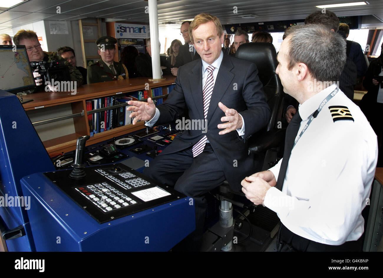 Taoiseach Enda Kenny (centre) chats with Navigator Basil Murphy onboard the Celtic Explorer vessel at Sir John Rogerson's Quay in Dublin, where he will announce 92 jobs in the marine sector. Stock Photo