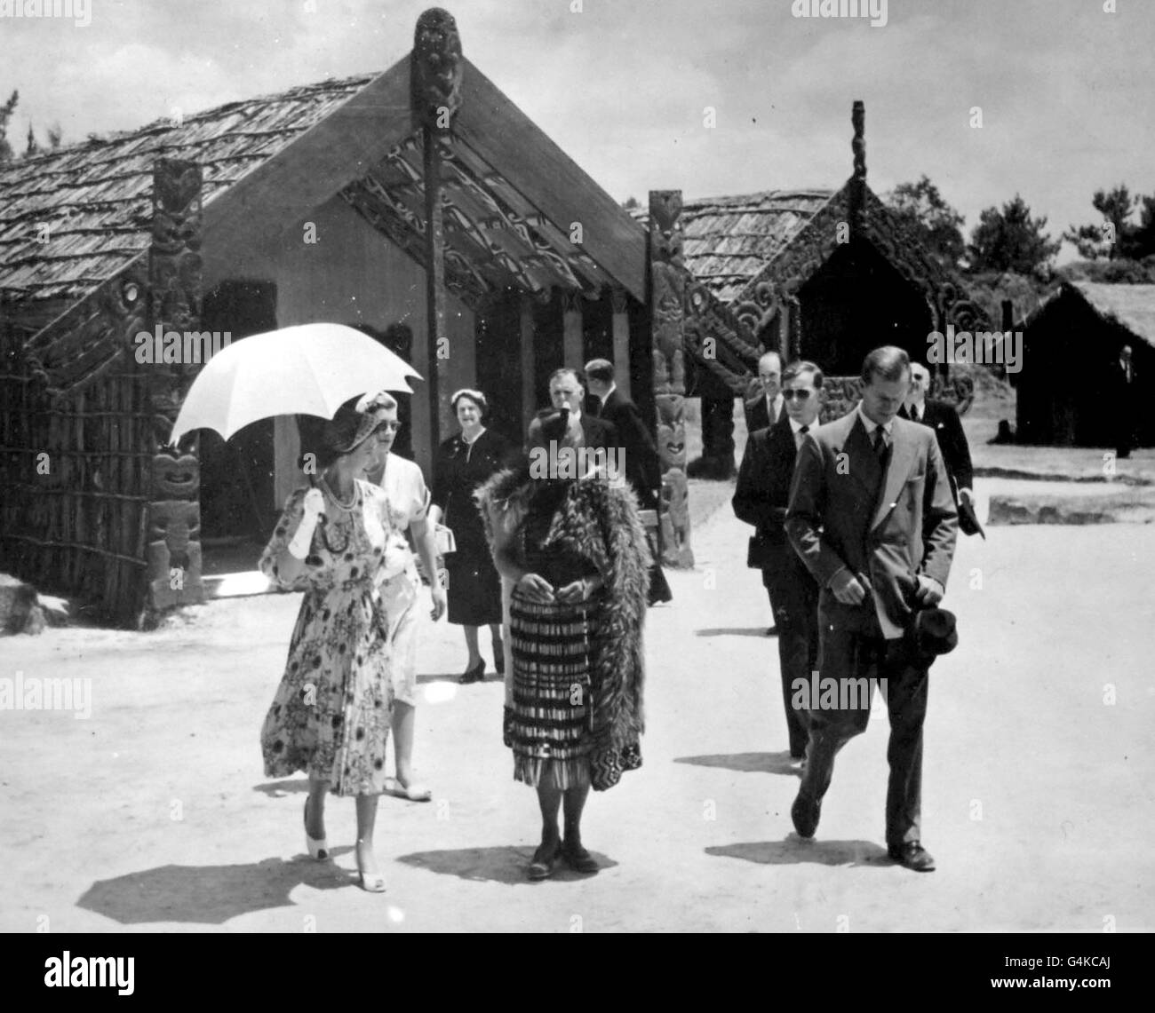 **Scanned low-res from contact** The Queen, sheltering beneath a sunshade, talks with Maori guide Rangi as she leaves the Meeting House during the visit to the Maori village of Whakarewarewa, during the royal tour of New Zealand. Stock Photo