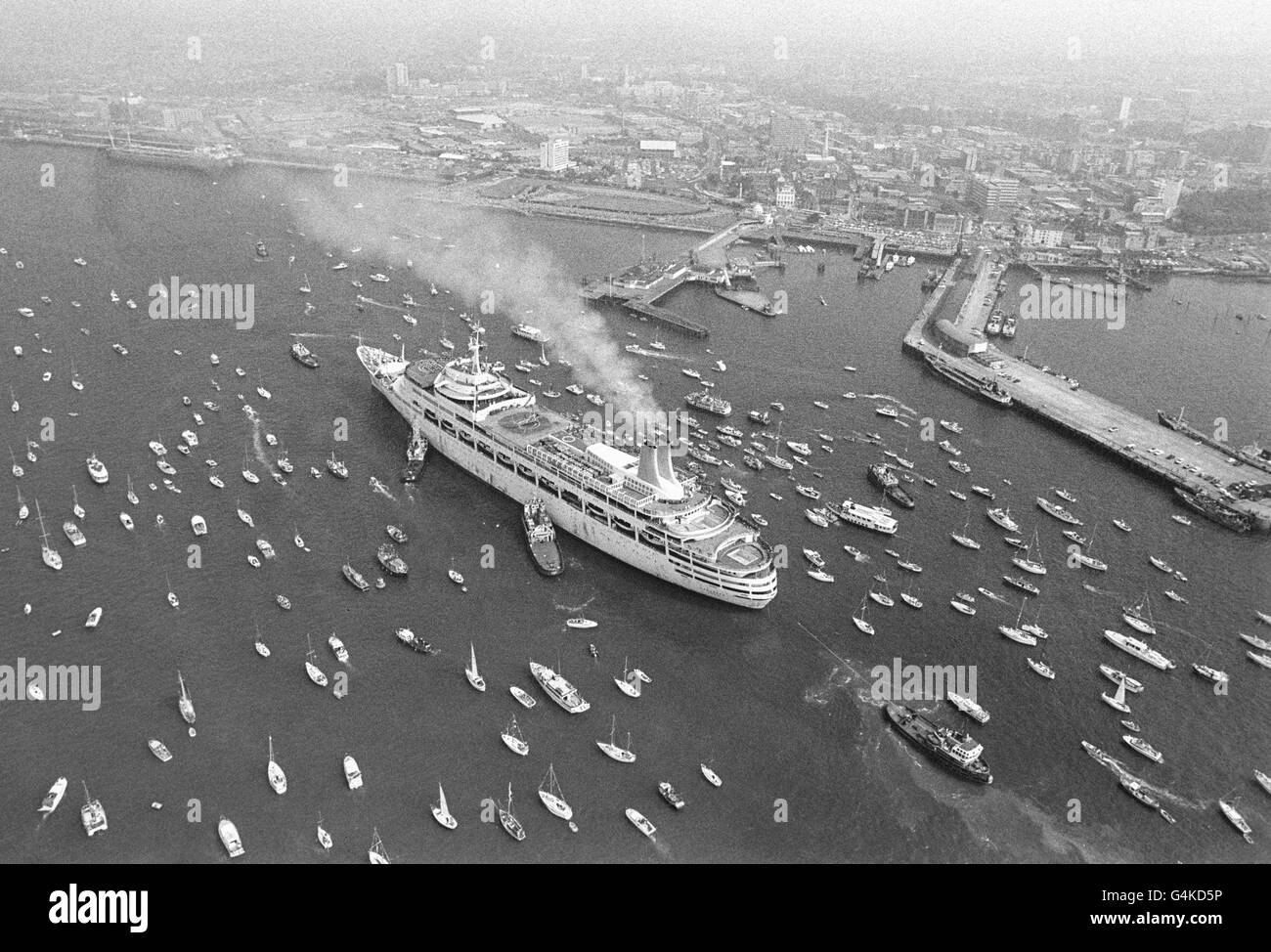 Aerial view of the Canberra, luxury liner turned troop carrier, as she came home to Southampton from the Falkland Islands conflict, escorted by hundreds of boats, yachts, tugs and dinghies, who greeted her between the Isle of Wight and Southampton. Stock Photo