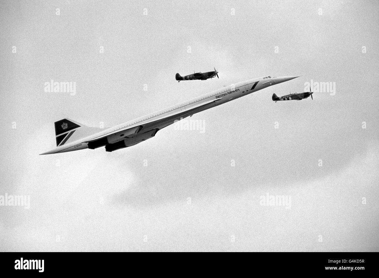 A British Airways Concorde is shadowed by two Second World War spitfires as it arrives to make passes over the Biggin Hill Air Show. Stock Photo