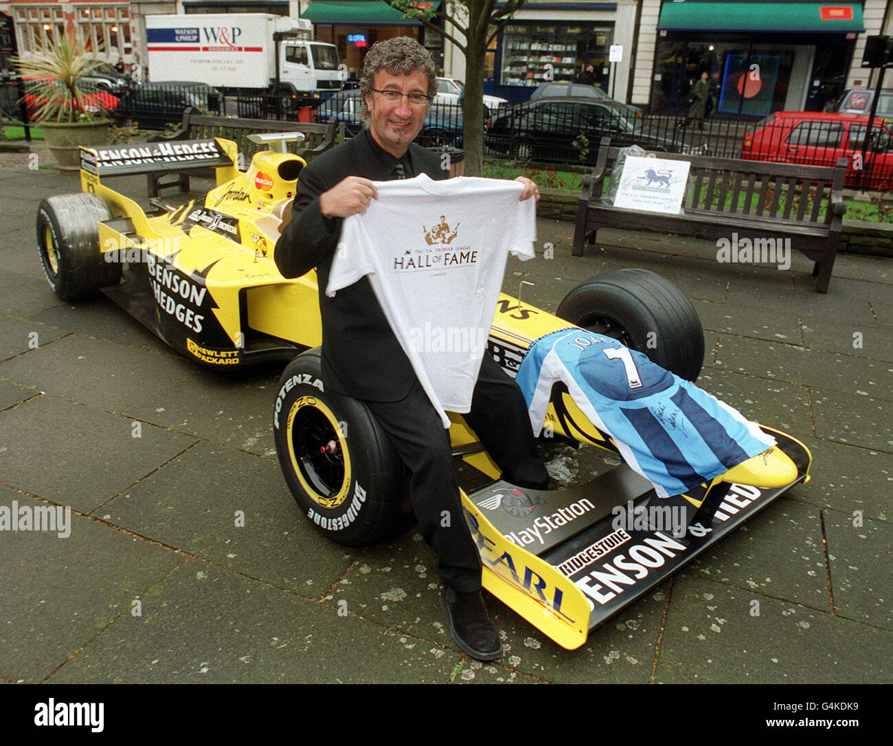 Jordan Grand Prix Chief Executive Eddie Jordan with one of his Formula One  cars in Golden Square, London, where he became a member of the Hall of Fans  by having his hand