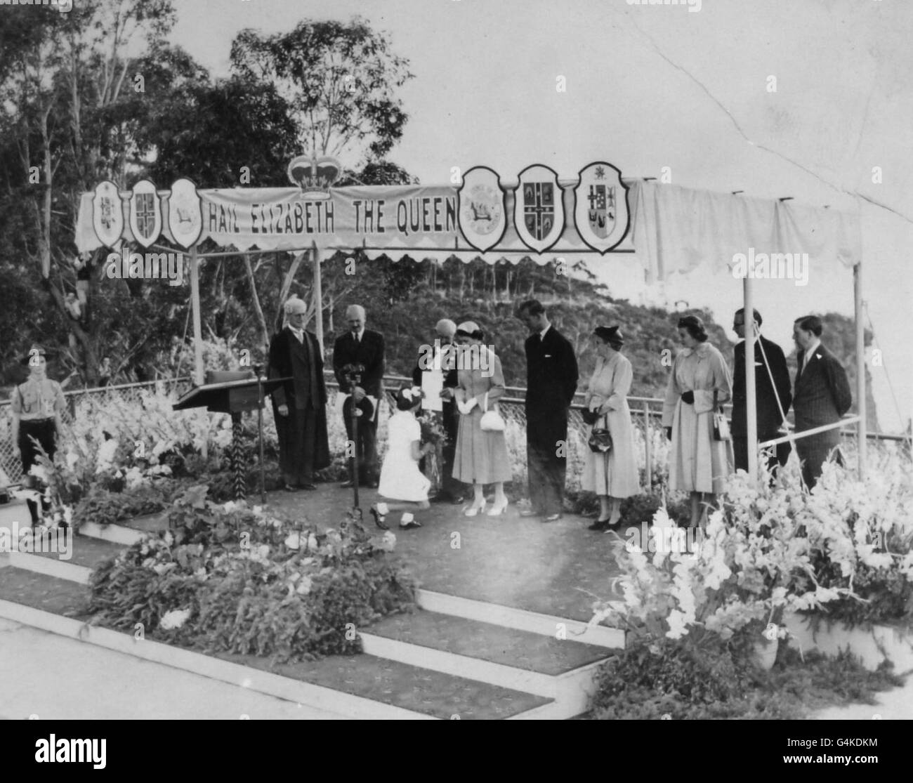 Rosemary Barrow, aged 11, curtseys to the Queen and presents a bouquet