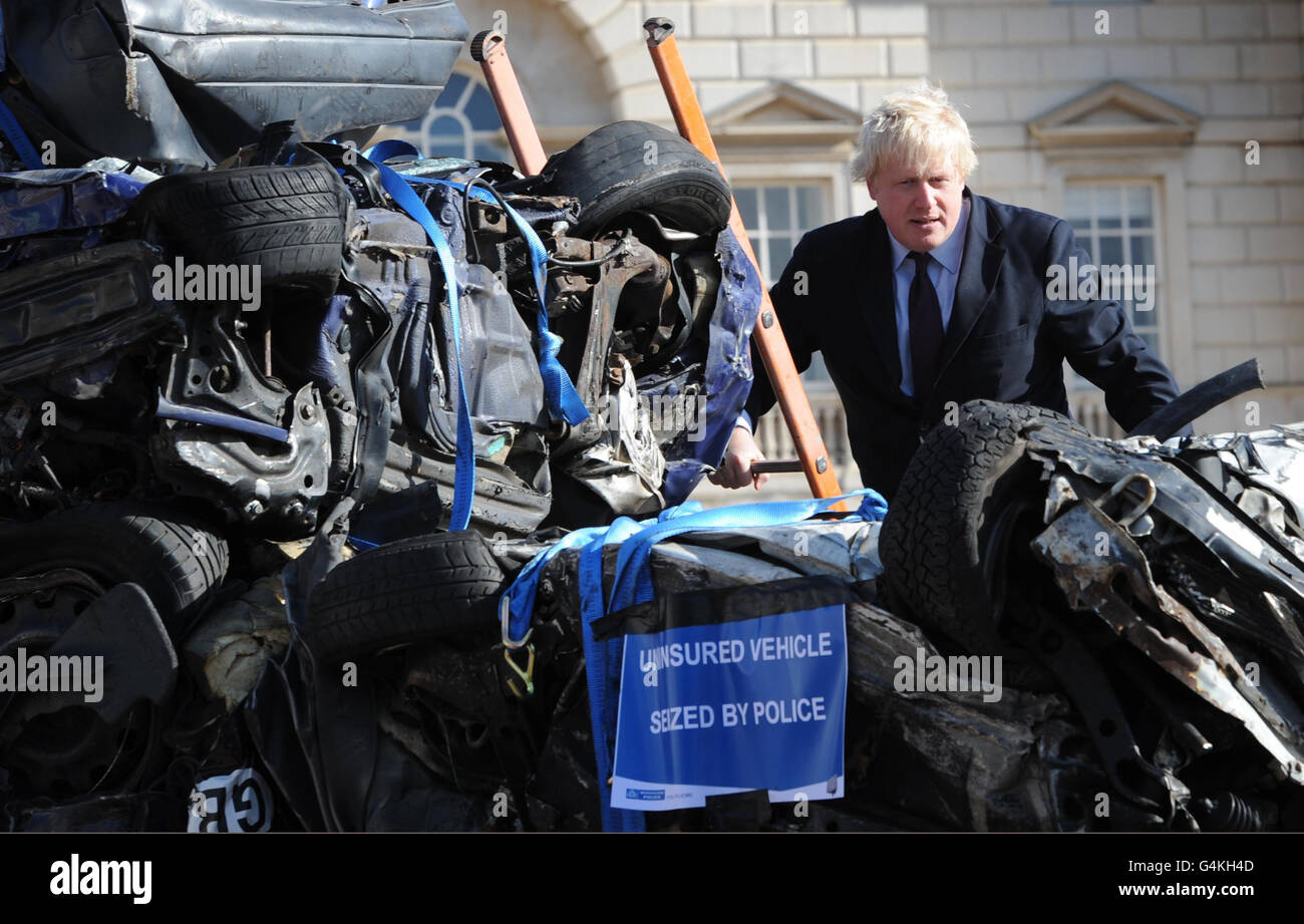 London Mayor Boris Johnson with a collection of crushed cars as a result of them being uninsured, on Horse Guards Parade in London today. Stock Photo