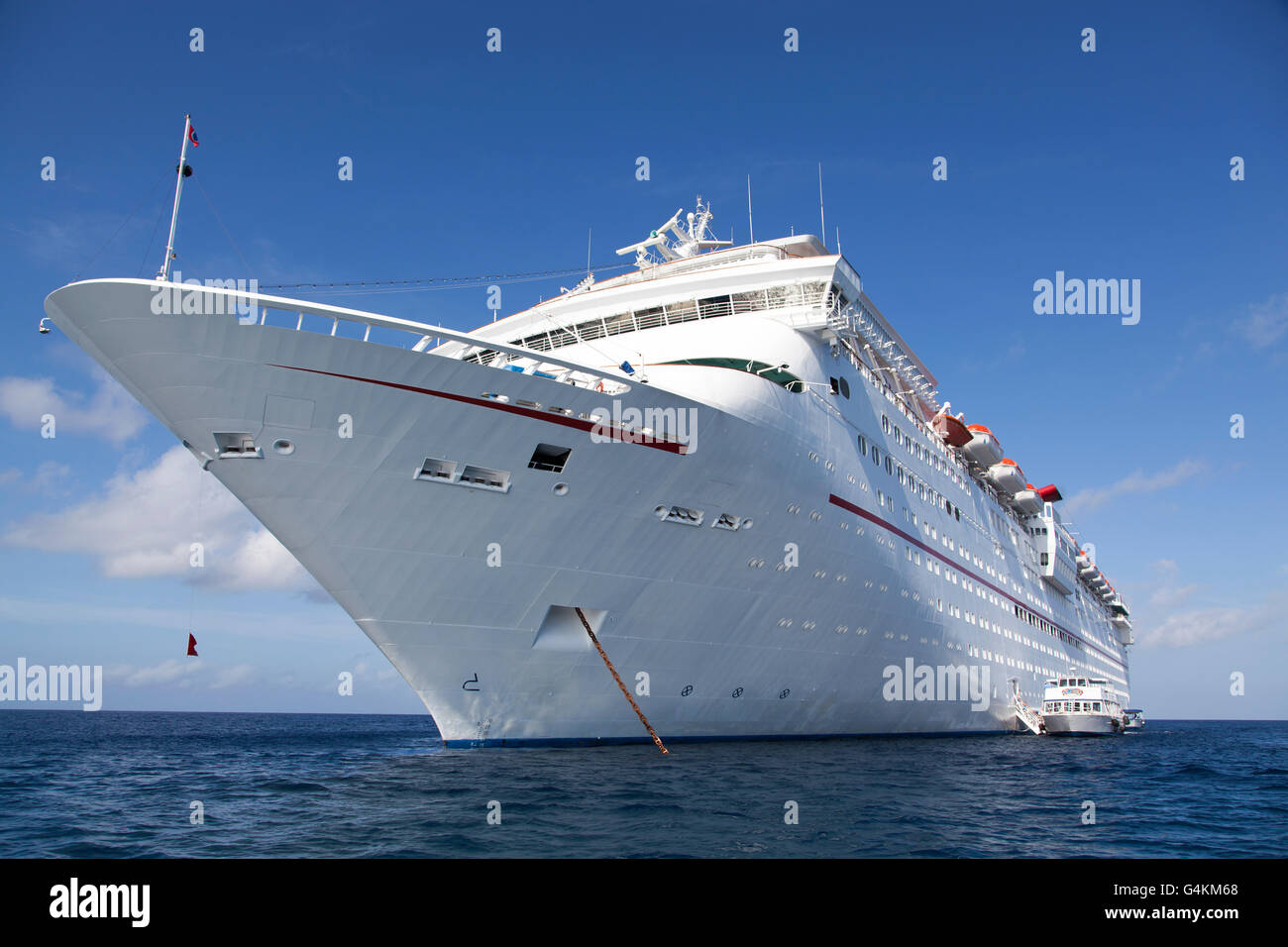 The anchored cruise liner with tender boats in operation on a side