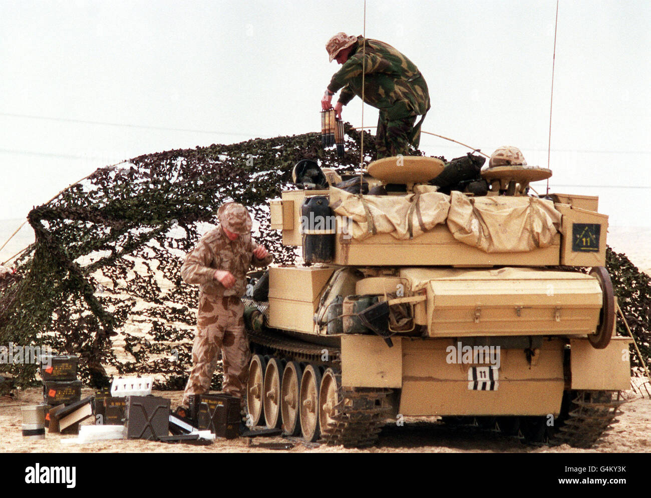 British soldiers during the Gulf War: An armoured vehicle of the 16th/5th Queen's Royal Lancers (part of 7th Armoured Brigade) is loaded with fresh stores and arms in the Saudi Arabian desert during the Gulf War. Stock Photo